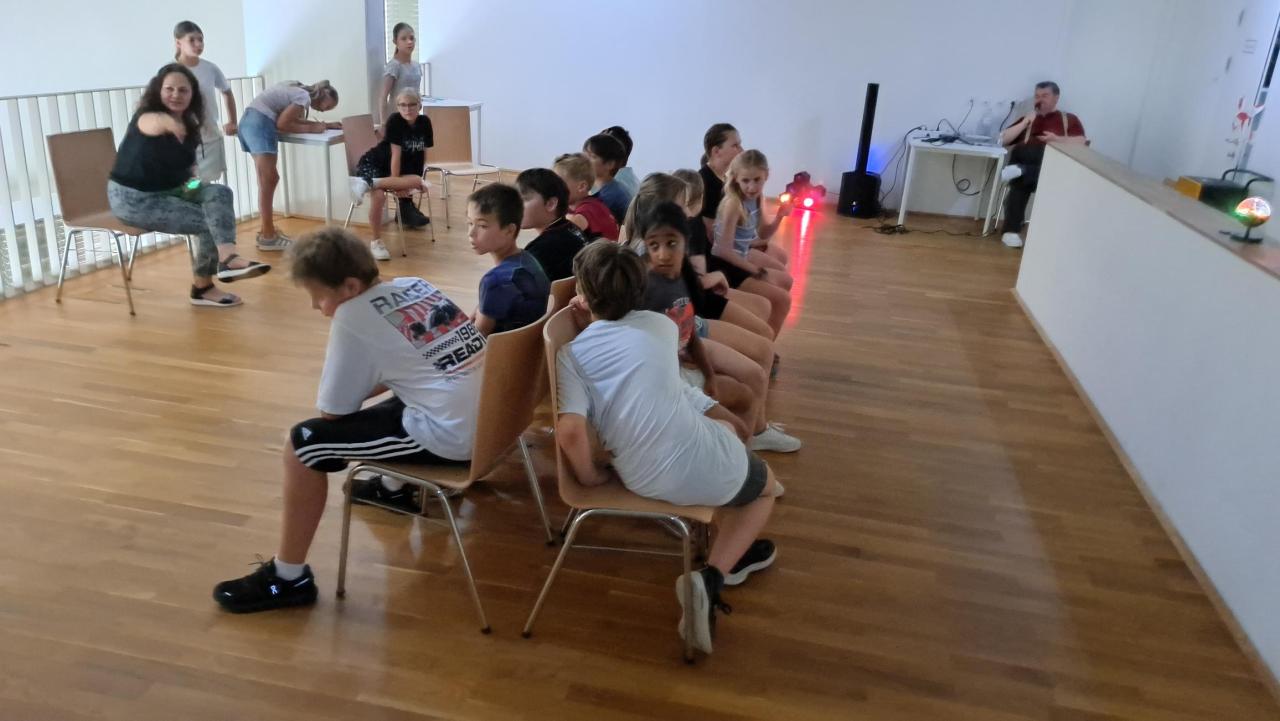 Kinder sitzen auf Sesseln für das Sesselkreisspiel